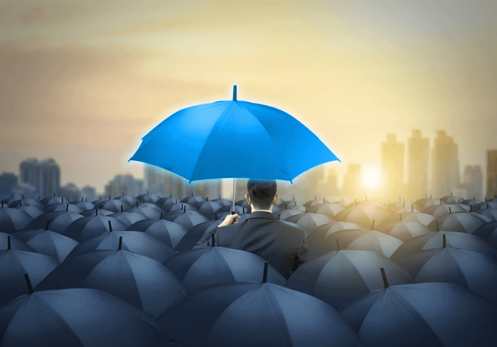 Homem de terno segurando guarda-chuva azul vibrante entre vários guarda-chuvas escuros, simbolizando como a comunicação visual pode diferenciar uma empresa no mercado.